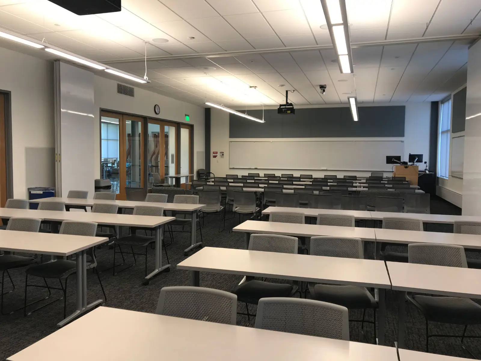 Several separate rows of chairs and tables in front of a podium in a Harmony campus classroom Several separate rows of chairs and tables in front of a podium in a Harmony campus classroom