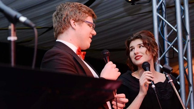 Two people singing at a music performance