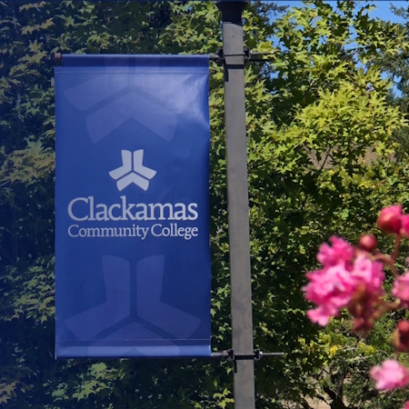 Clackamas Community College in spring showing a school banner and flowers
