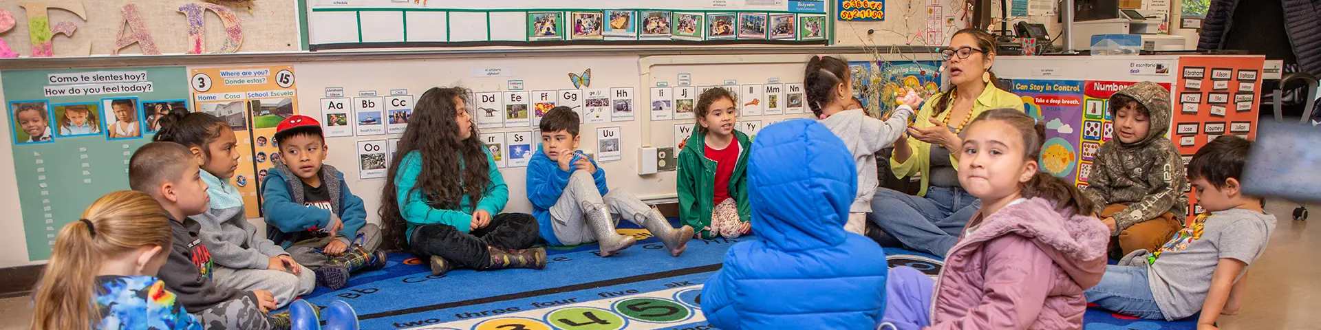 Teacher interacts with classroom of young children sitting in a circle
