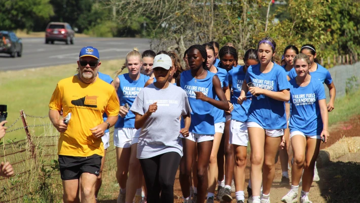 President Tim Cook runs with Lane Community College women's soccer team