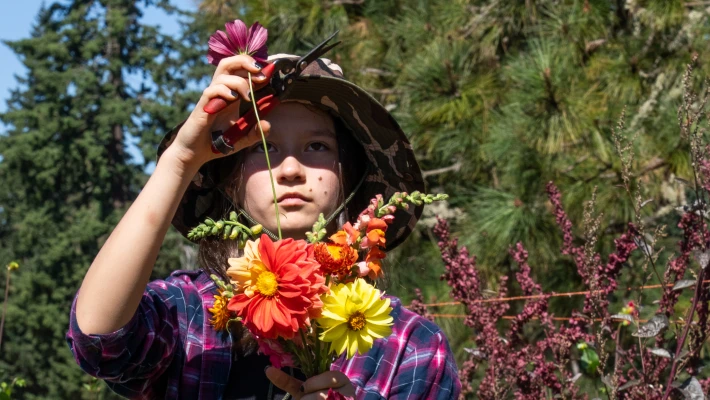 Student farmer adds a flower to a bouquet