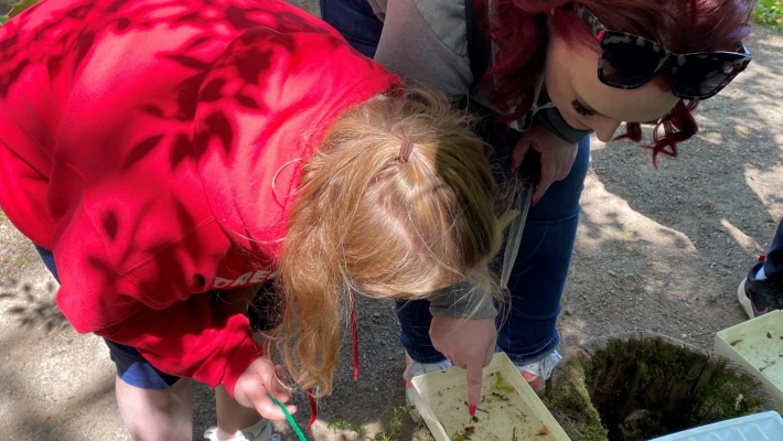 A mother and daughter look at organisms in a sample of water