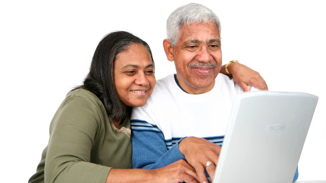 Two people look at a laptop together