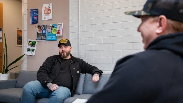 Veterans talk while relaxing on a couch at CCC's VET Center